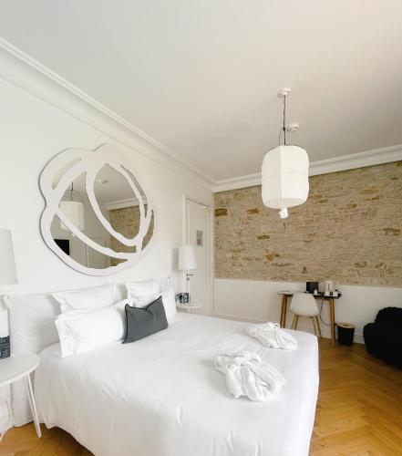 a bedroom with a white bed and a large mirror at Les Garennes - Hôtel Spa Bénodet in Bénodet