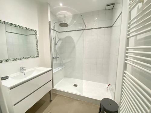 une salle de bain blanche avec une douche et un lavabo dans l'établissement Le Patio plain-pied face port, à Étaples