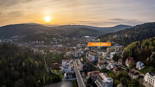 Zielony Zdrój, Sun & Snow في كرينيتسا زدروي: مدينة في الجبال مع لافتة مكتوب عليها هاري فيلت