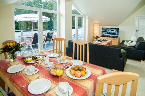 ein Esszimmer mit einem Tisch mit Essen drauf in der Unterkunft Appartementhaus Ostseeresidenz in Warnemünde
