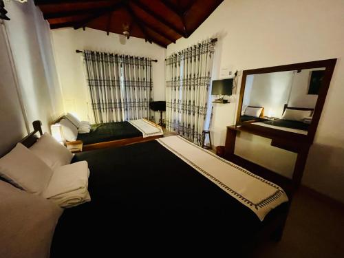 a bedroom with a large bed and a mirror at The Heritage Inn in Kandy