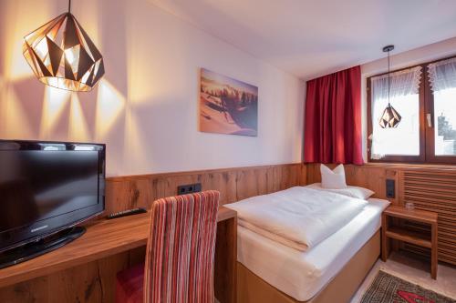 Habitación de hotel con cama y TV de pantalla plana. en Das Elisabeth en Sankt Anton am Arlberg