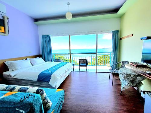 a bedroom with a bed and a view of the ocean at 永旺旅店 Yong Wong Hostel in Nanwan