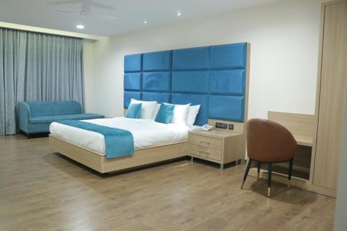 a bedroom with a large bed and a chair at Pt Moolraj Residency in Una