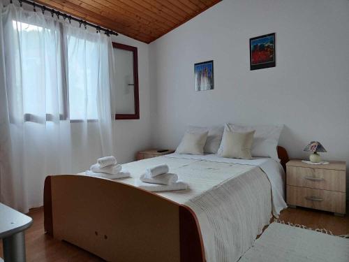 a bedroom with a bed with two towels on it at Dragana in Basina
