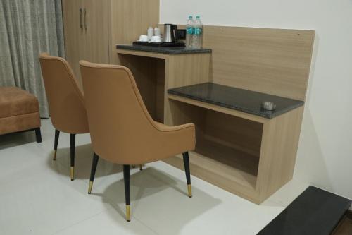 a desk and two chairs in a hotel room at Pt Moolraj Residency in Una