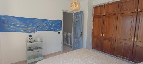 1 dormitorio con armarios de madera y puerta azul en Casa Luz, en Yaiza