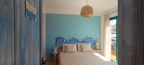 a bedroom with a bed with a blue wall at Casa Luz in Yaiza