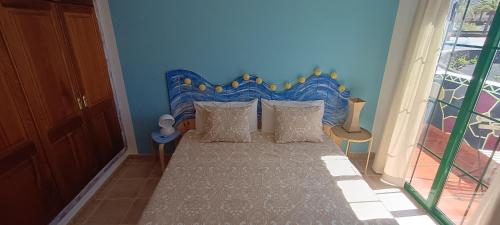 um quarto com uma cama com uma cabeceira azul em Casa Luz em Yaiza