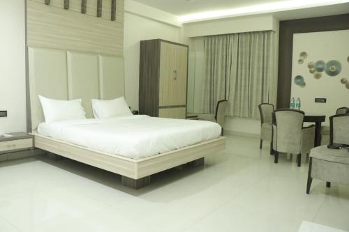 a bedroom with a bed and a table and chairs at Pt Moolraj Residency in Una