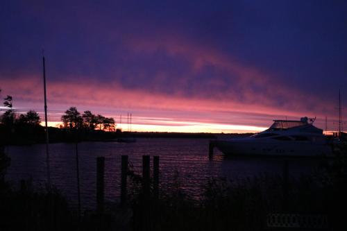 a boat sitting in the water at sunset at 4 pers house Cecil with own fishing spot on a dutch chanel in Anjum