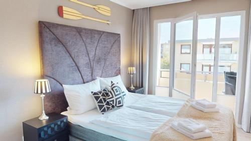 Un dormitorio con una cama grande con una ventana grande. en Das Solaris 9 Luxury Beach Apartment mit Balkon und moderner Ausstattung, en Grömitz