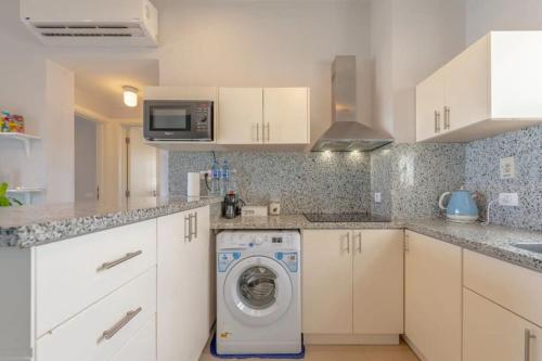 una cucina bianca con lavatrice al suo interno di El-Gouna Water-Side Apartment a Hurghada