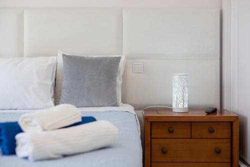a bedroom with a bed and a nightstand with a lamp at Zurrinha holidays whit jacuzzi in Quarteira