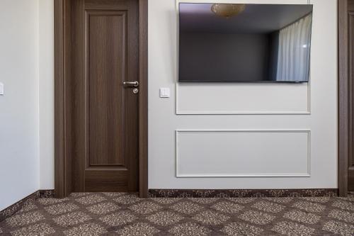 a door with a flat screen tv on a wall at Gradiali Wellness and SPA in Palanga