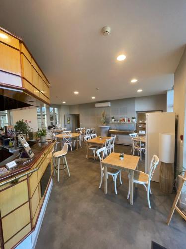 a restaurant with tables and chairs and a kitchen at Résidence Haut 2 Gammes - Gîte de séjour in Saint-Hippolyte