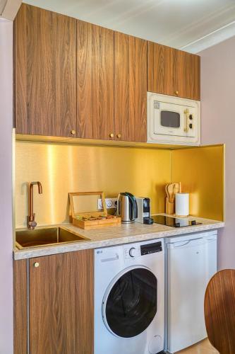 une cuisine avec un lave-linge et un micro-ondes dans l'établissement Melody suite in Paris, à Courbevoie