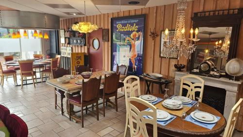 une salle à manger avec une table, des chaises et une cheminée dans l'établissement Au P'tit Quinquin, à Céaux