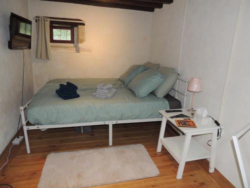 ein kleines Schlafzimmer mit einem Bett und einem Tisch in der Unterkunft Rêves et Chaudrons in Vicq-Exemplet