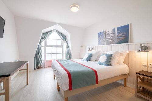 a bedroom with a bed with a desk and a window at Pierre & Vacances Premium Résidence de la Plage in Le Crotoy