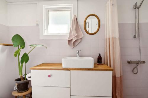 Baño blanco con lavabo y espejo en Spacious Summer House With Pool,, en Vejby