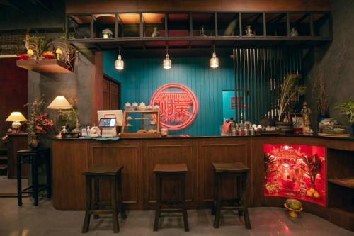 un bar en un restaurante con taburetes delante en Caiyong Hometel & Cafe's Studio, en Khlong San