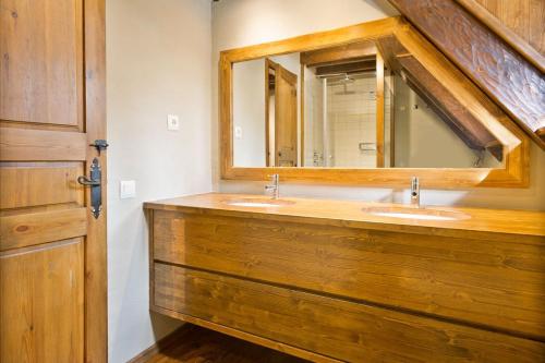uma casa de banho com 2 lavatórios e um espelho grande em Luderna - Casa con terraza Cuylas em Baqueira-Beret