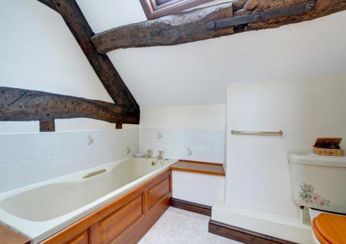 ein Bad mit einer Badewanne und einem WC in der Unterkunft Hendy in Gwaynynog