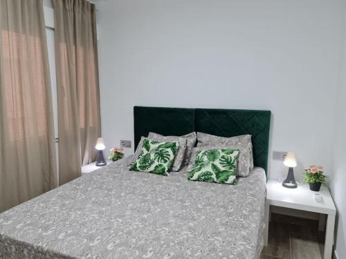 a bedroom with a bed with two green pillows at Precioso Apartamento Acondicionado al Lado del MAR in Calafell