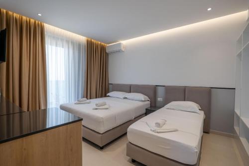 a hotel room with two beds and a television at Hotel Emblem in Sarandë