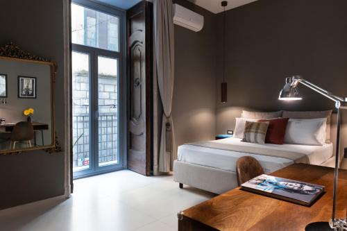 - une chambre avec un lit et une table avec un bureau dans l'établissement Aledo Boutique Apartments, à Naples