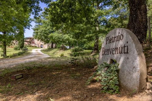 a stone sign with a plant on it at Pietraio in Radicondoli