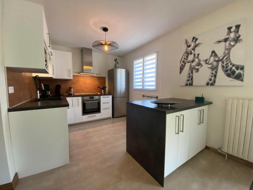 a kitchen with white cabinets and a black counter top at Chez Tad Kozh Maison familiale in Paimpol