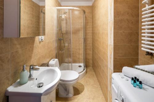 e bagno con servizi igienici, lavandino e doccia. di Duplex Penthouse with hammock a Cracovia