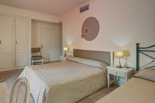 a bedroom with two beds and a mirror on the wall at Hotel Castell Blanc in Empuriabrava