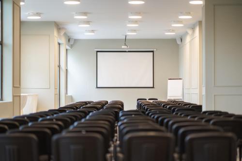 an empty room with rows of chairs and a whiteboard at Maxi Park Hotel & Spa in Velingrad