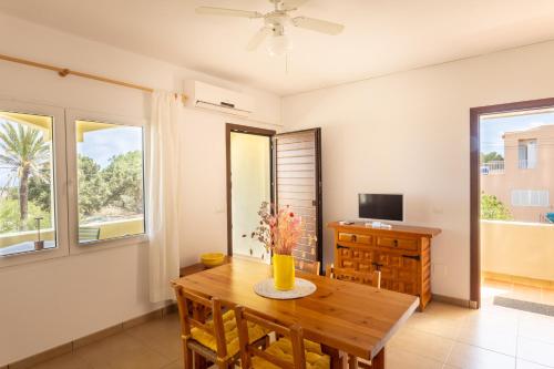 a dining room with a table and a television at Apartamentos Verde Mar in Es Pujols