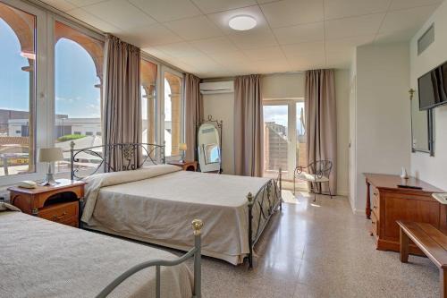 a hospital room with two beds and a balcony at Hotel Castell Blanc in Empuriabrava