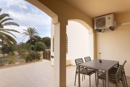 ein Esszimmer mit einem Tisch und Stühlen auf einer Terrasse in der Unterkunft Apartamentos Verde Mar in Es Pujols