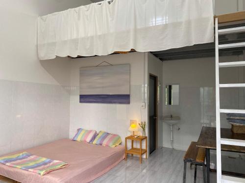 Schlafzimmer mit einem Bett mit rosa Bettwäsche und Kissen in der Unterkunft Summer Stations Homestay Binh Chau - Ho Coc Beach - Vung Tau in Xuyên Mộc
