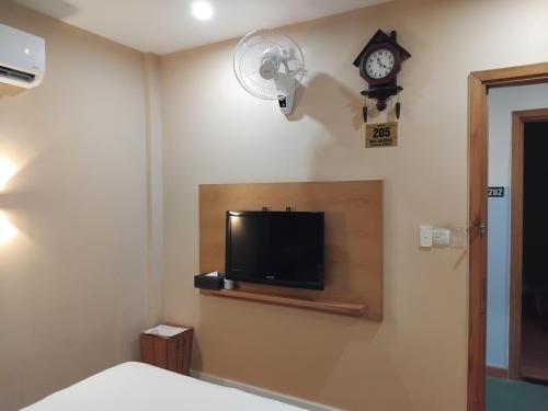 a bedroom with a tv and a clock on the wall at A25 Hotel - 142 Bùi Thị Xuân in Ho Chi Minh City
