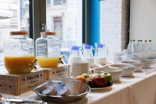 a table with bottles of milk and bowls of fruit at Palazzo Bellezia Luxury Suites & Spa in Turin