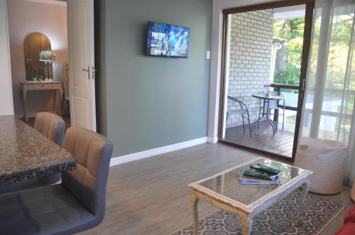 a living room with a table and a view of a patio at 62 on Adderley in George