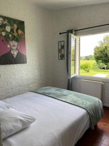 een slaapkamer met een bed met een bloemschilderij aan de muur bij Annexe du Château La Rose des Vents in Puisseguin