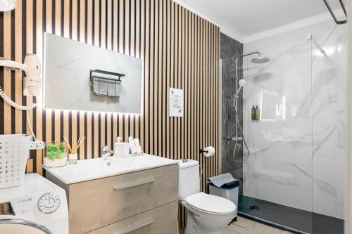 ein Bad mit einer Dusche, einem Waschbecken und einem WC in der Unterkunft Apartamento Rockbeach in Costa Teguise