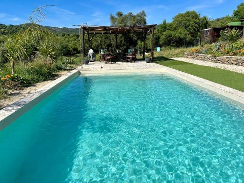 a swimming pool in a yard with a gazebo at Preciosa Casa de Madera, Andalucía in Prado del Rey