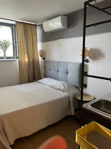 a small bedroom with a bed and a sink at GARDEN HOUSE Madrid in Madrid