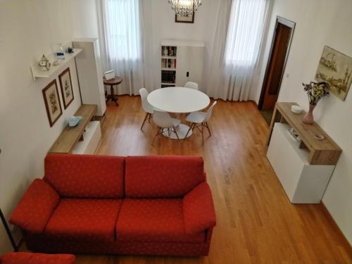 salon z czerwoną kanapą i stołem w obiekcie Casa MIA w Wenecji