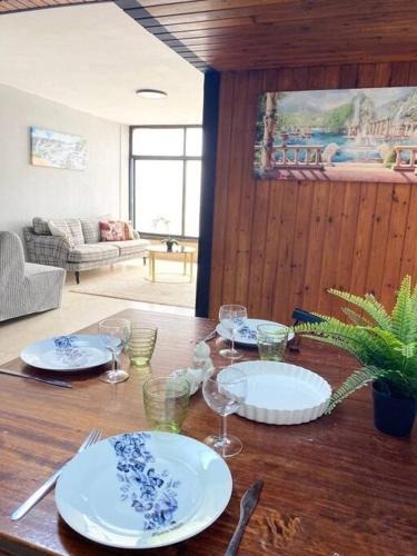 a wooden table with plates and wine glasses on it at Apartment on the Mermaid beach in Qiryat Yam