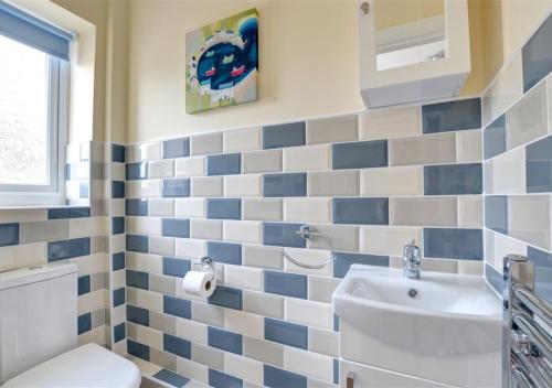 DyffrynにあるTredegarの青と白のタイルの壁のバスルーム